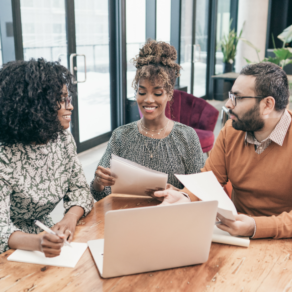 A happy couple meeting with a mortgage loan officer reviewing paperwork